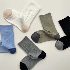Detail view of mid-calf socks featuring elegant swallow jacquard and contrast heel design.