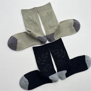 Detail view of cotton mid-calf socks with delicate bird and leaf jacquard knit textures.