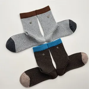 Detailed view of women autumn winter striped mid tube socks featuring color block design metal buttons.