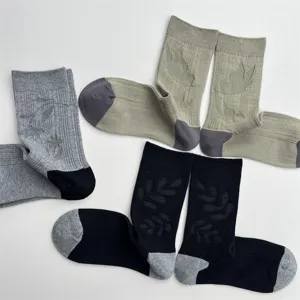 Detail view of cotton mid-calf socks featuring subtle jacquard patterns and contrast heels.