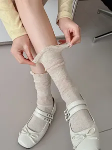 Detail shot of beige mesh ruffle crew socks, showcasing breathable texture and delicate lace cuffs.