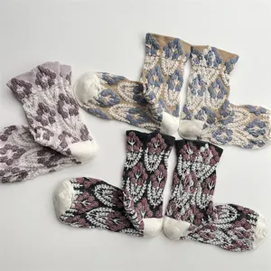 Detailed close-up of vintage floral knitted mid-tube socks with textured embossed pattern.