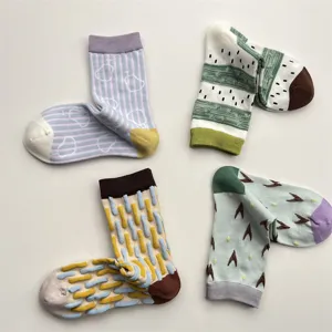 Détail de chaussettes en coton avec des motifs géométriques irréguliers et des blocs de couleurs.