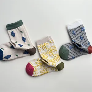 Close-up of cute Korean retro embossed floral cotton mid-calf socks with contrast colors.