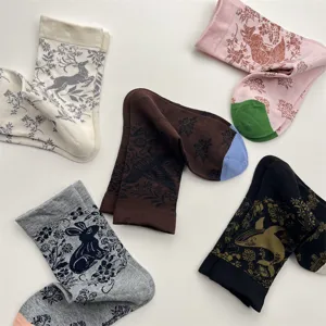 Close up of vintage style cotton mid-tube socks featuring detailed animal and botanical prints.