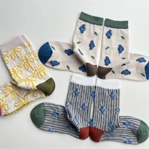 Close-up detail of vintage embroidered floral cotton mid-calf socks with contrast color toes.