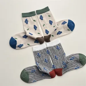 Close-up detail of stylish women mid-calf socks with cute floral patterns, cozy and soft fabric.