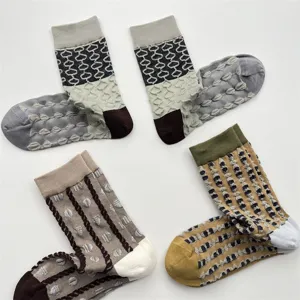 Detailed view of women's 3D geometric pattern cotton mid-tube socks with contrast lines.
