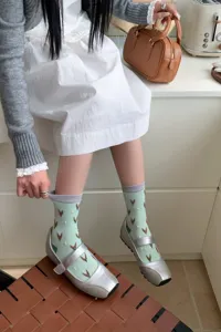 Vue détaillée de chaussettes vertes tendance aux motifs géométriques irréguliers.