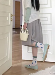 Detail shot of cute floral cotton mid-calf socks worn with green flat shoes daily