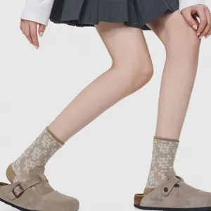 Detail shot of vintage geometric pattern mid-calf cotton socks worn with stylish clogs.