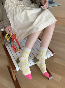 Detail view of retro women's cotton mid-calf socks with yellow embossed pattern and color block.