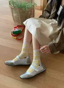 Close-up detail shot of Korean style retro cute yellow relief floral pattern cotton socks.