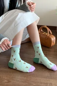 Chaussettes montantes vert menthe pour femme avec motifs géométriques marron et contrastes.