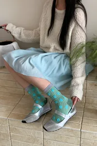 Detailed view of women's cute green polka dot cotton mid-tube socks in retro style.