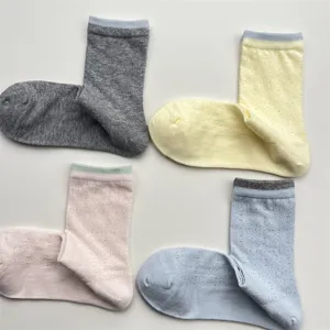 Detail view of women's vintage hollow mesh mid-tube socks with cute color block cuffs.