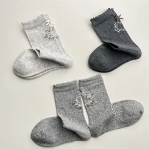 Detailed view of sweet Korean style floral embroidered cotton mid-tube socks with cute bows.