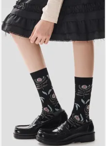 Vue détaillée de chaussettes mi-mollet à fleurs botaniques noires avec des mocassins.
