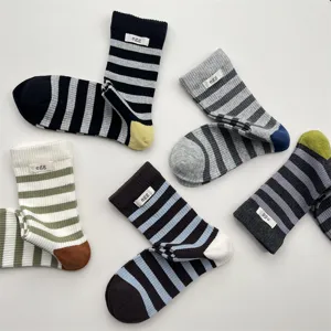 Close-up of stylish striped mid-calf socks with cute letter label, soft cotton fabric.