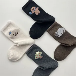 Detail view of cute cartoon embroidered crew socks, featuring soft plush teddy bear and cat patterns.
