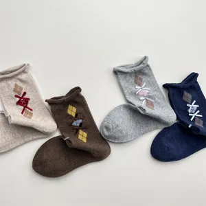 Close-up detail of retro argyle pattern mid-tube socks with cute bows and soft roll-top.