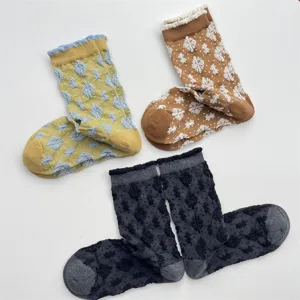 Close-up detail of textured floral mid-tube socks with cute ruffled lace cuffs and vintage style.