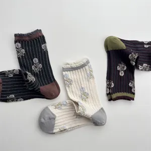 Detail shot of vintage floral mid-tube socks with textured vertical stripes and ruffles.