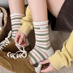 Close-up detail of Korean retro style rolled edge striped cotton mid tube socks with tag.