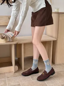 Close-up detail of vintage style retro mid-calf socks with diamond pattern and rolled cuffs.