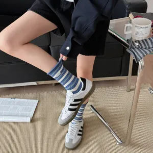 Detail shot of Korean style striped mid-calf socks with cute fabric label and breathable cotton.
