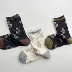 Detailed close-up of retro floral mid-calf socks with vertical stripes and contrast color cuffs.
