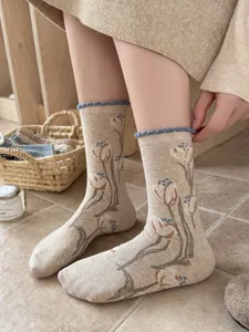 Close-up detail of vintage style tulip print mid-calf socks with cute lettuce edge.