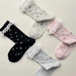 Vue détaillée de chaussettes mi-mollet à fleurs de style japonais avec bordure en dentelle.