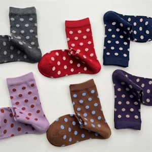 Gros plan sur les chaussettes en coton à pois colorés, texture de tricot d'hiver douillette.