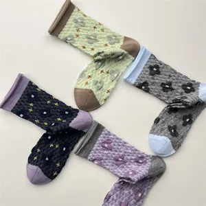 Detailed view of vintage textured floral mid-calf socks with contrast rolled cuffs.