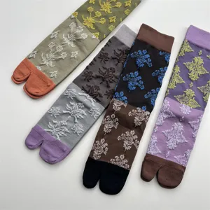 Vue détaillée de chaussettes tabi japonaises vintage en coton à relief floral coloré.