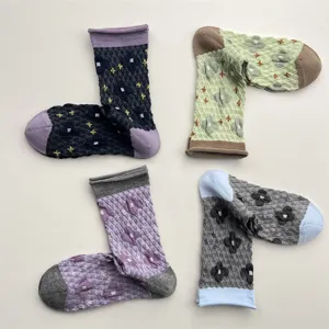 Detailed close-up of Japanese vintage embossed floral mid-tube socks with contrast rolled cuffs.