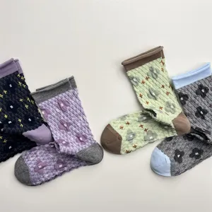 Detail view of vintage embossed floral mid-calf socks with contrast rolled cuffs and cozy knit.