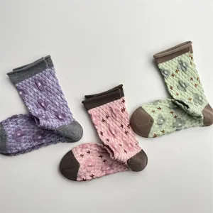 Detailed shot of Japanese vintage embossed floral mid-tube socks with contrast rolled cuffs.