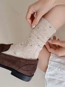 Detailed shot of vintage floral mid-tube socks paired with brown loafers, breathable mesh.