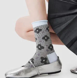 Vintage grey mid-calf socks with contrast blue cuffs and elegant floral relief pattern.