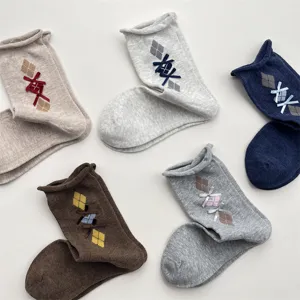 Detail view of vintage style knit socks featuring classic argyle pattern and cute bows.