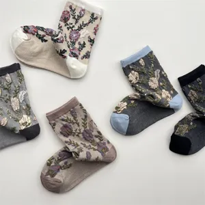 Detailed view of vintage floral embroidered mid-calf cotton socks with retro color blocking.