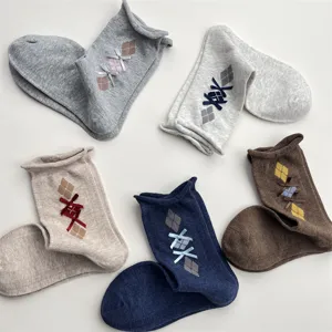 Detailed view of Korean style retro rolled edge argyle knit socks with cute bow accents.