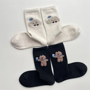 Close-up detail of cute cartoon cloud and bear embroidery plush mid-calf socks for winter.