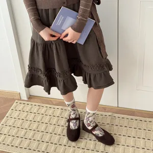 Detailed shot of floral patterned mid-tube socks paired with retro brown shoes and lifestyle.