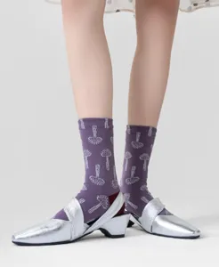 Detail shot of women's vintage plant patterned cotton mid-calf socks with silver shoes.