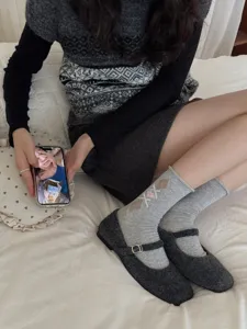 Detail view of Korean retro rolled-edge argyle mid-tube socks featuring cute bow decoration.