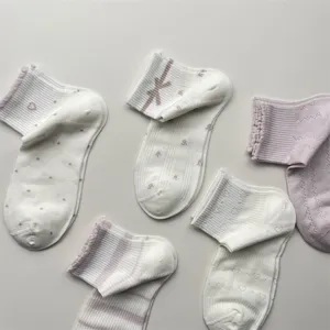 Nahaufnahme Details atmungsaktiver Baumwollkurzsocken mit süßen Schleifen, Streifen und Mustern.