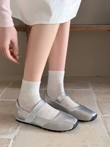 Stylische silberne Metallic Mary Jane Flachschuhe mit süßen weißen Feinstrümpfen.